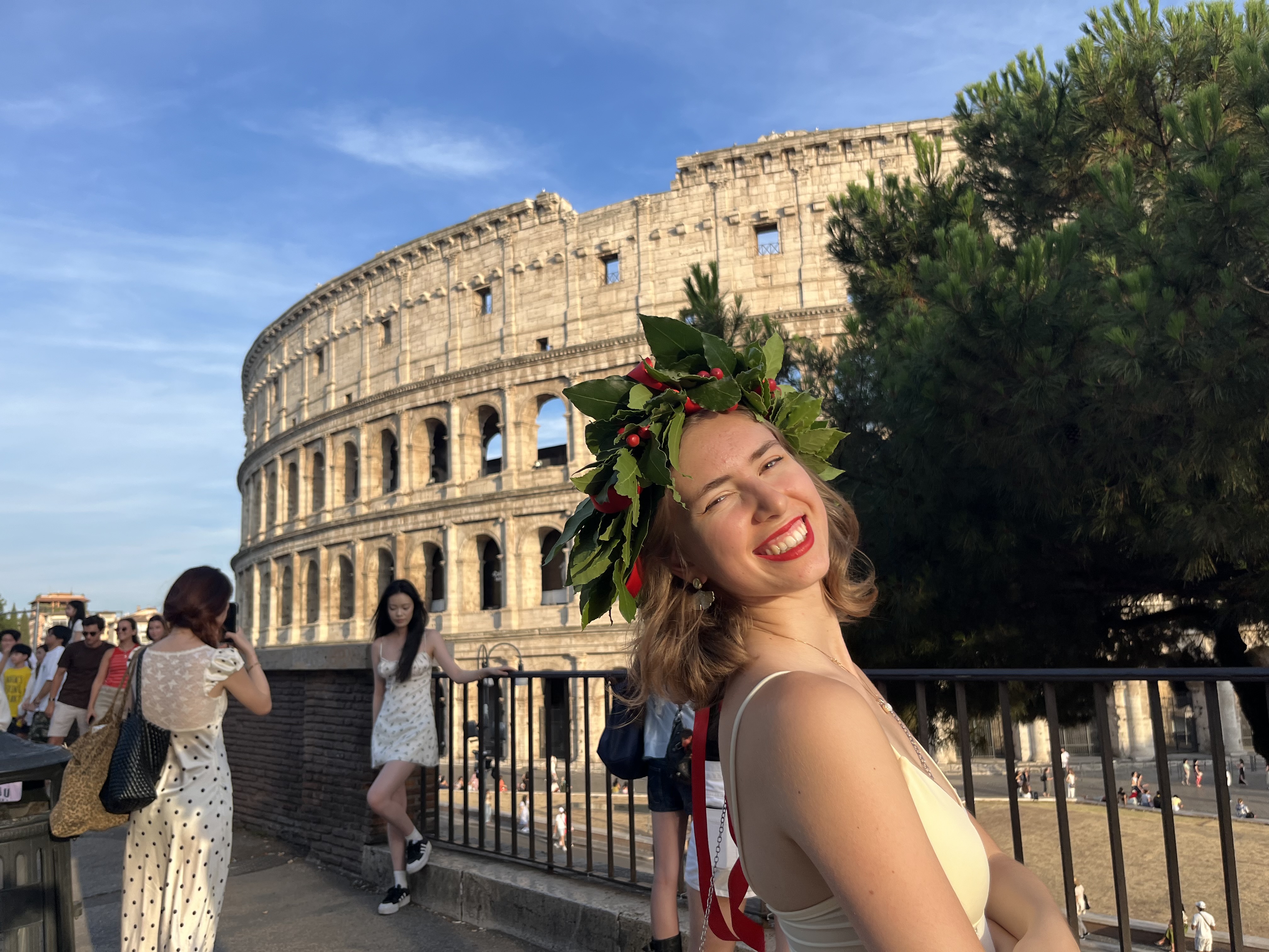 Aylin Eda Ergün smiling in front of the Colosseum with a laurel crown