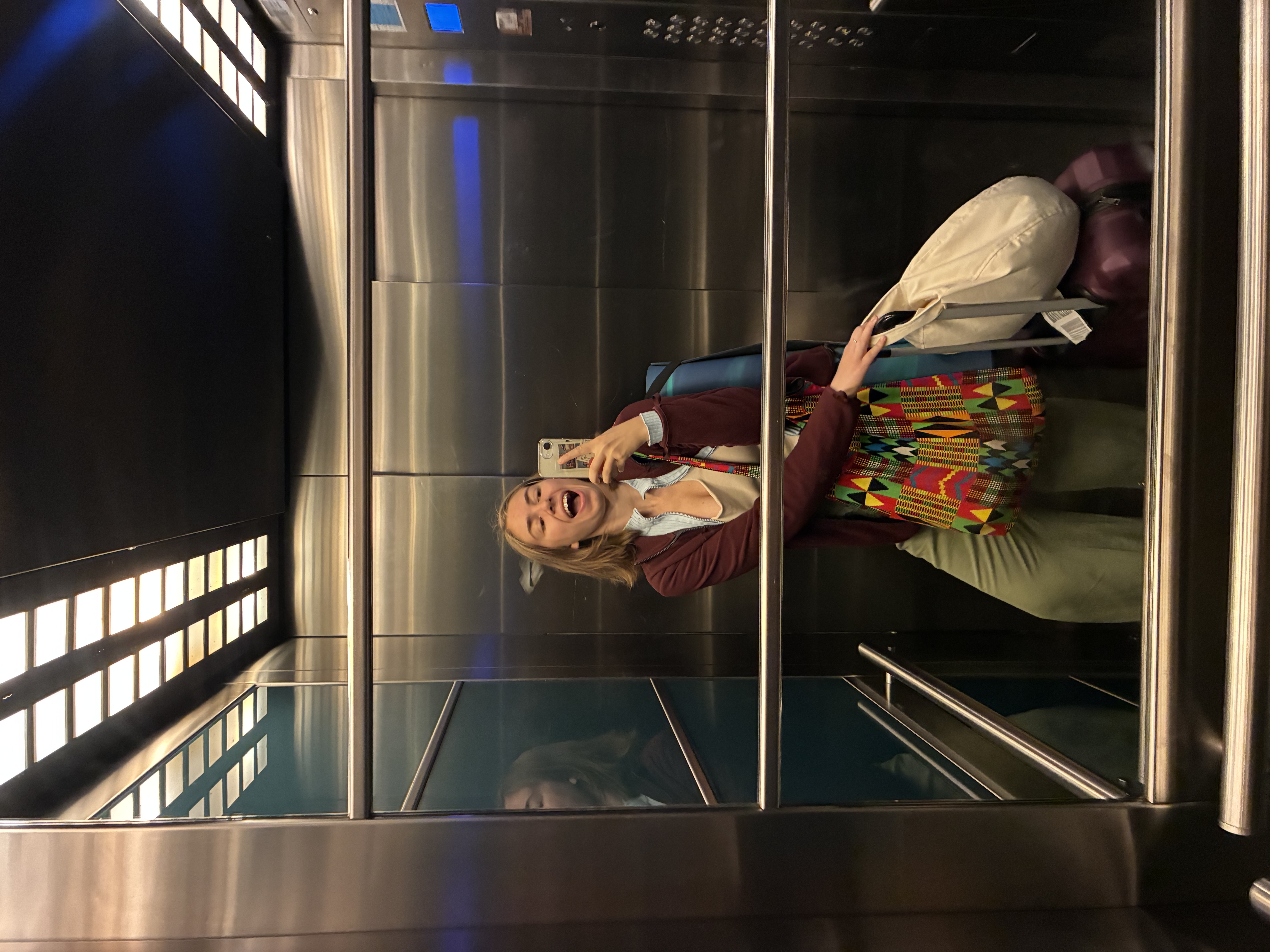Aylin Eda Ergün taking an elevator mirror photo while traveling with luggage