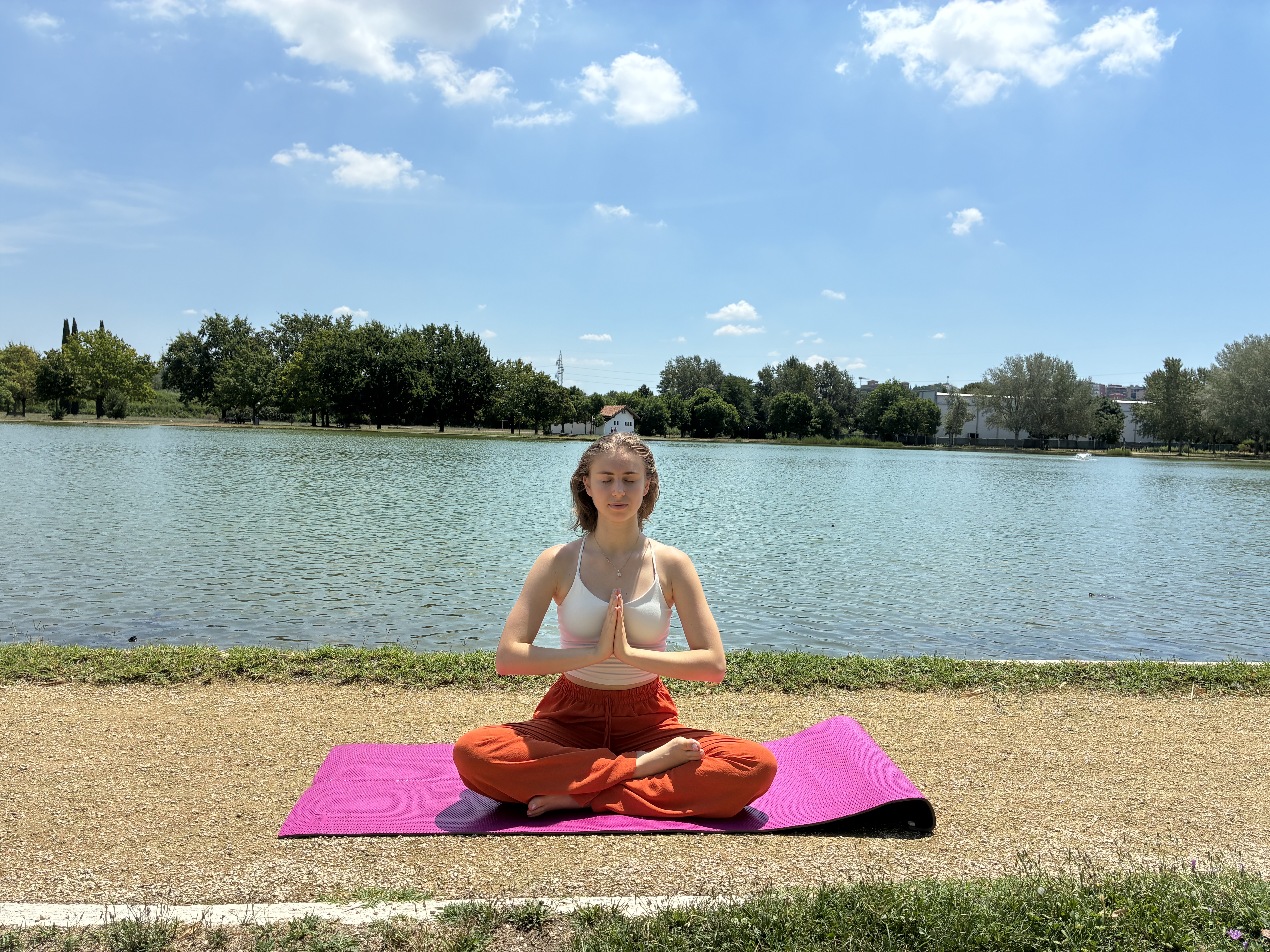 Aylin Eda Ergün practicing yoga beside a lake